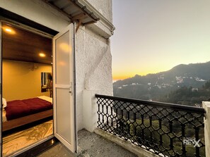 A balcony with a metal railing overlooking a hillside.