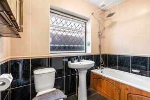 Une salle de bain avec des toilettes, un lavabo et une baignoire.