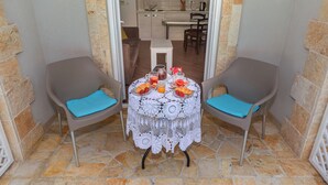 A small outdoor dining area with two chairs and a table set for breakfast. - Apartments Fortunella (Petrovac)