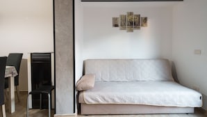 Ett modernt vardagsrum med en soffa, ett litet bord och en stol.