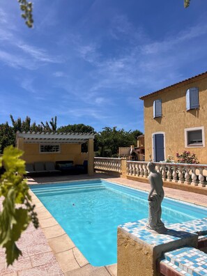 A swimming pool with a tiled deck, a statue, and a building with blue shutters. - Villa located 35mn from the sea(Fréjus,Ste Maxime) gorges du Verdon(lac SteCroix) (Flayosc)