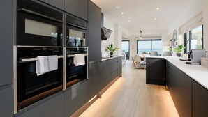 Una cocina moderna con electrodomésticos integrados, comedor con vistas y un diseño limpio y minimalista.