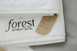 A folded white towel with the text "forest RETREAT HOTEL" and a tag with the same name. - Forest Retreat Center (Kyiv)