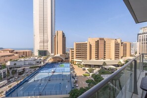 A view of a tennis court with surrounding buildings, including a tall skyscraper and a hotel named 'Royal Meridien'. - Premium 2 Bedroom in Trident Residence JBR (Dubai)