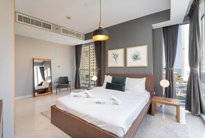 Quarto de hotel moderno com uma cama grande, uma mesa de cabeceira, um espelho e vista para a cidade.