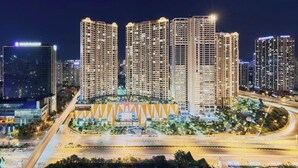 A high-rise building complex with multiple floors, surrounded by well-lit streets and other buildings.
