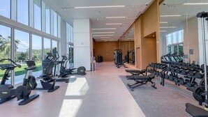 Een moderne sportschool met cardioapparatuur, gewichtbanken en haltersets.