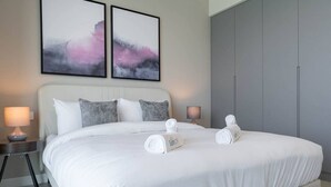 A modern hotel room with a large bed, two bedside tables with lamps, and abstract artwork on the wall. - Beautiful 2 Bedroom Sea Views at La Vie JBR (Dubai)