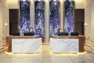 A reception area with marble counters and a mosaic wall.