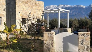 A stone building with a white pergola in front, a mountain backdrop, and a clear sky. - Quiet house in southern Crete, picturesque sea and mountain views, beach within walking distance (Pitsidia)