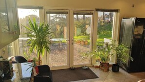 A modern kitchen with a sliding glass door leading to a patio area. - Drumee Lodge (Castlewellan)