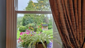 A window with a view of a garden and a small building. - Drumee Lodge (Castlewellan)