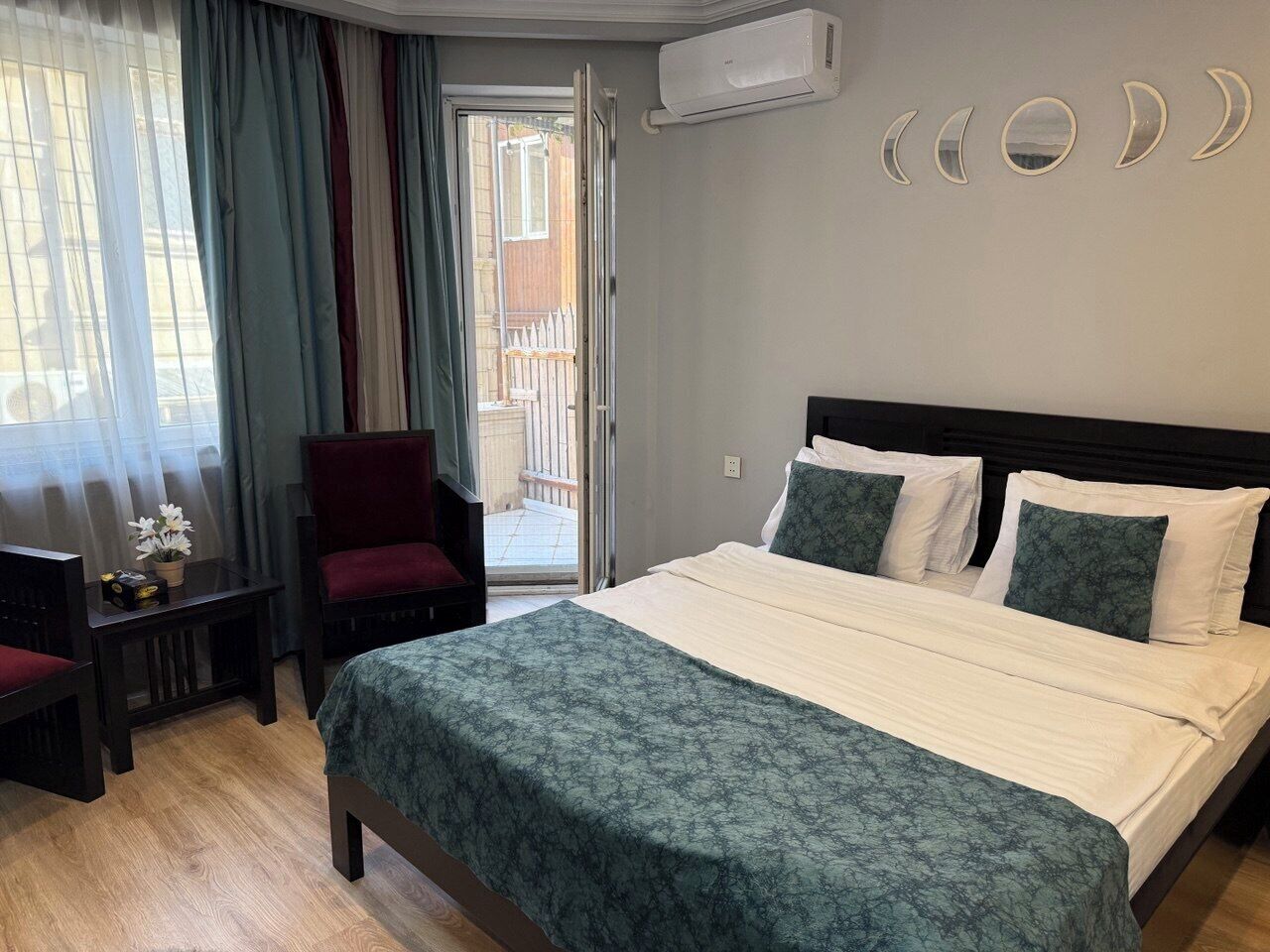 Habitación de hotel con cama, escritorio, silla y vistas al exterior.