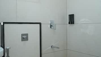 Een moderne badkamer met toilet, douche en een doorzichtige prullenbak.