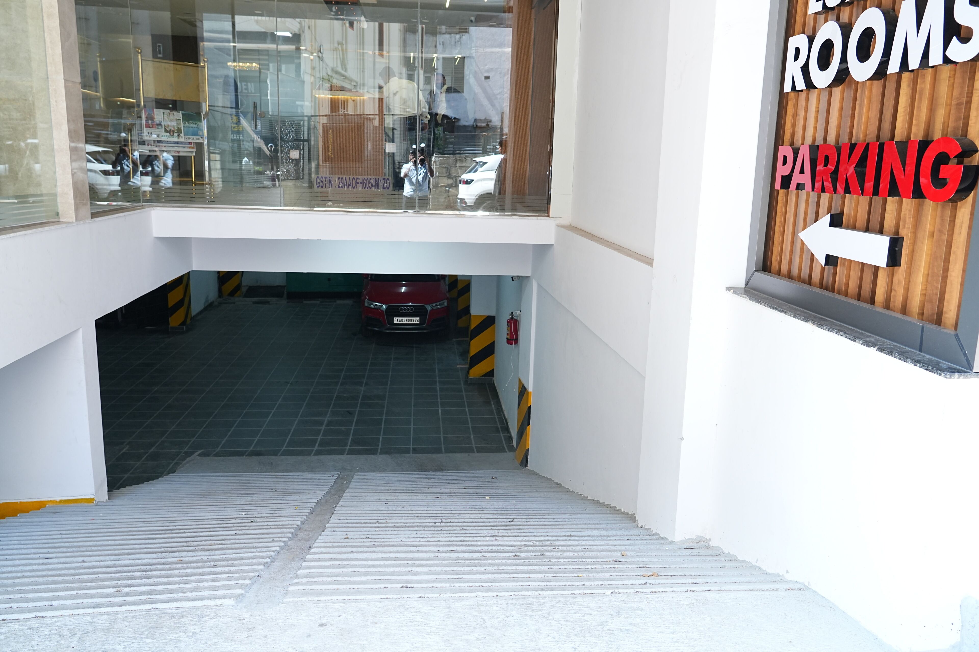 A hotel entrance with a sign indicating rooms and parking.