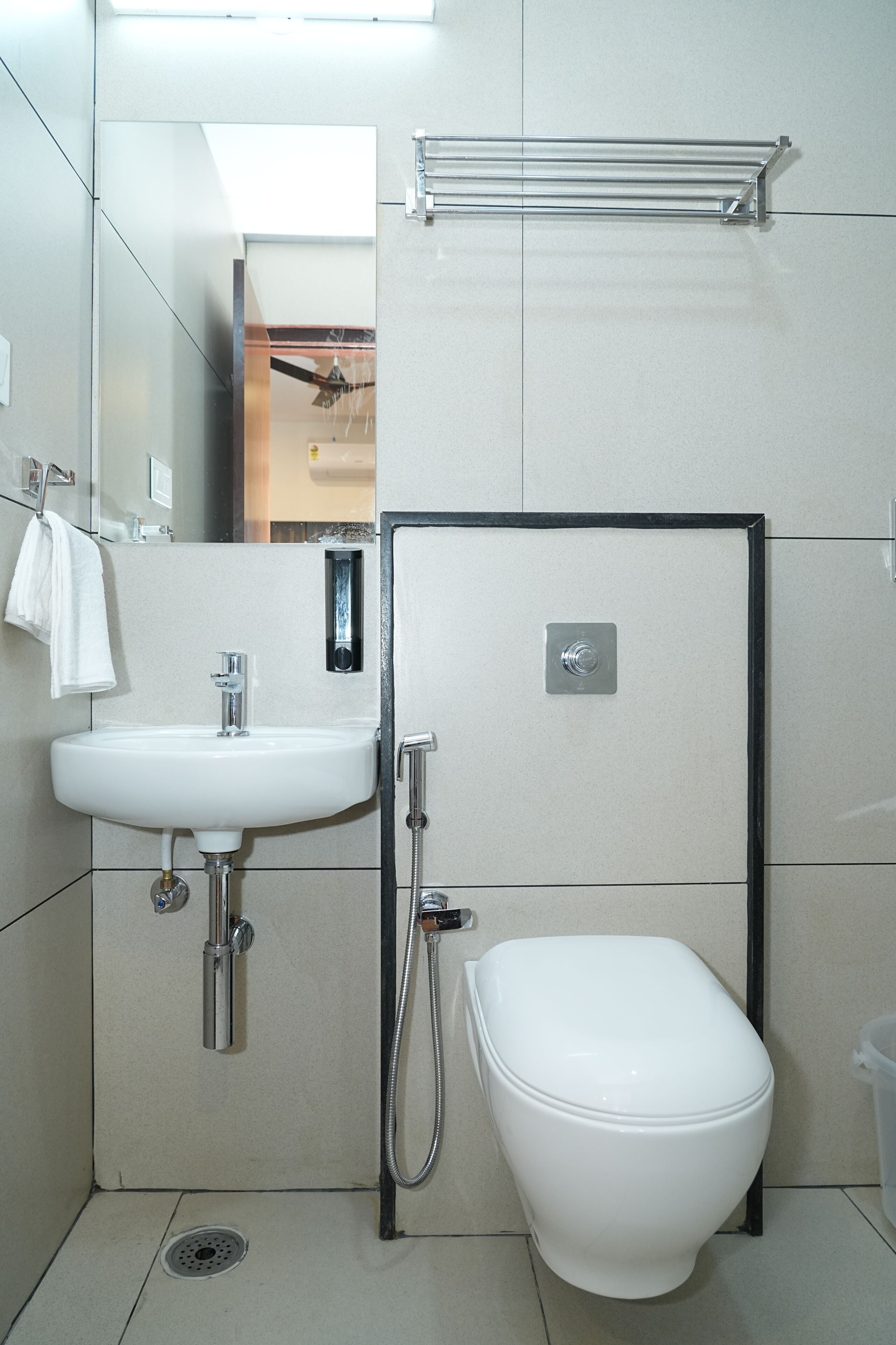 A modern bathroom with a white sink, toilet, and shower.