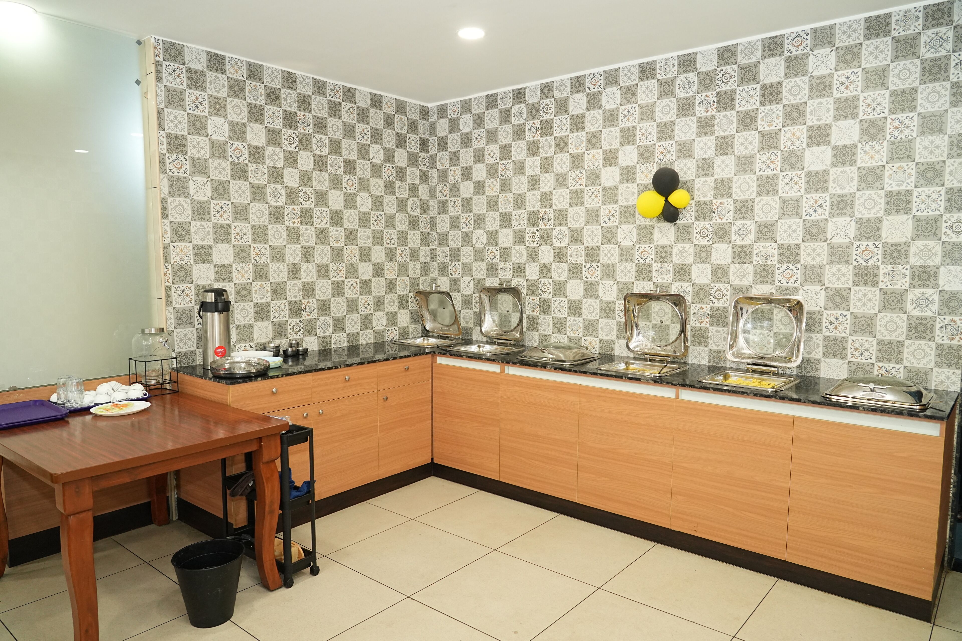 A kitchen with a checkered backsplash, a wooden countertop, and a sink.