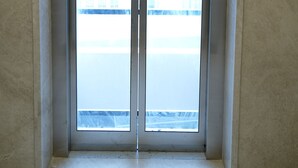 An elevator with glass doors and a control panel on the wall. - Hotel Grand Sigma (Bengaluru)