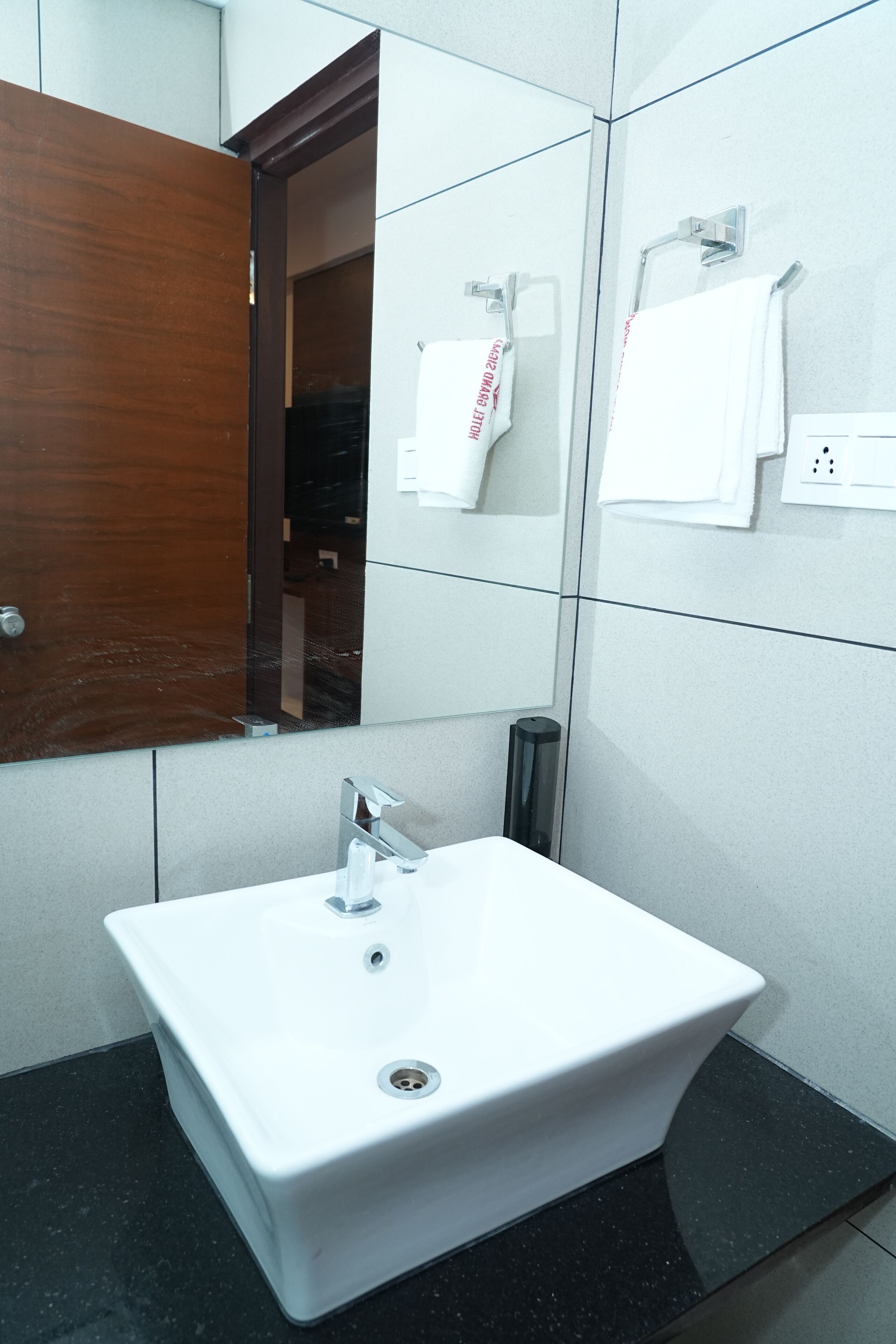 Ein Badezimmer mit Waschbecken, Spiegel und Handtuchhalter.