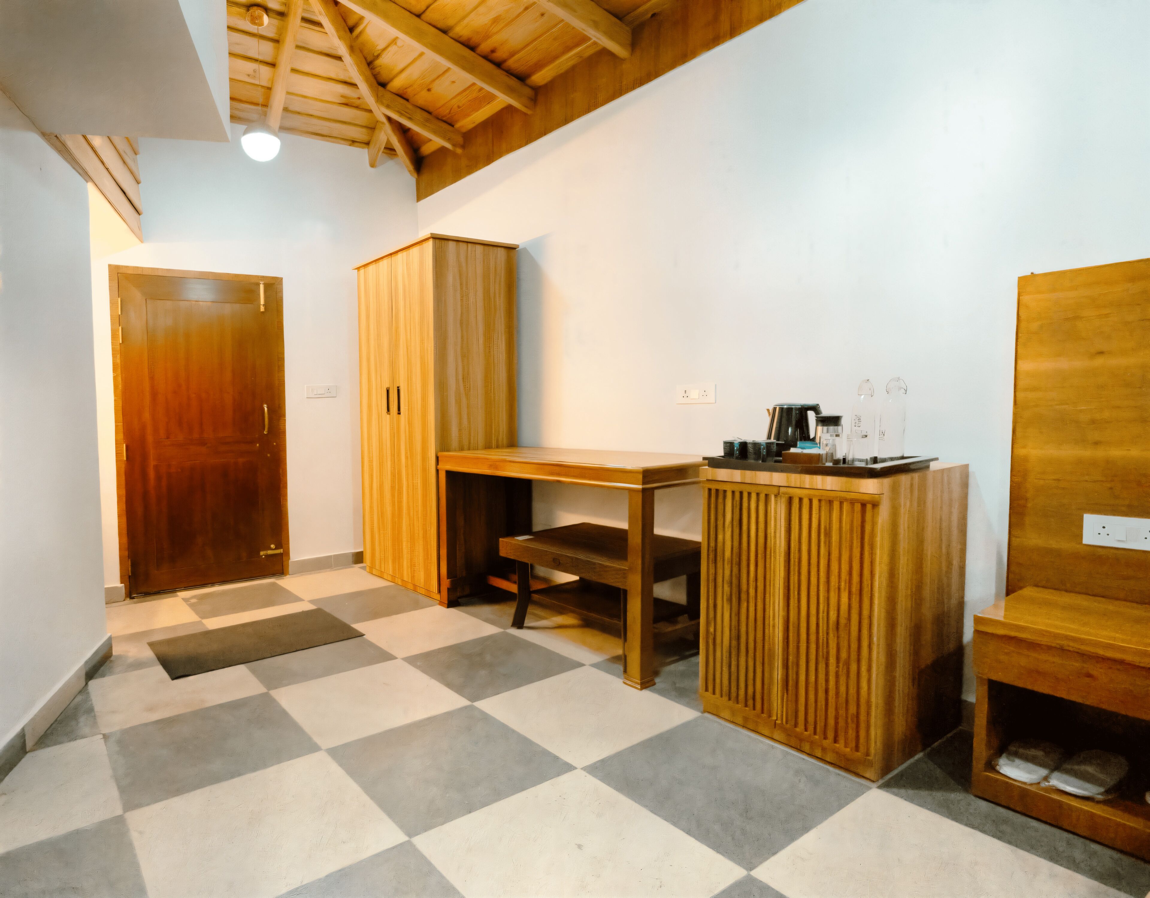 A room with a checkered floor, wooden furniture, and a ceiling with exposed beams.