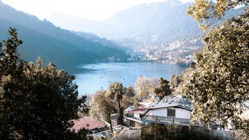 A lakeside view with a mountain backdrop, a small town, and a bridge.