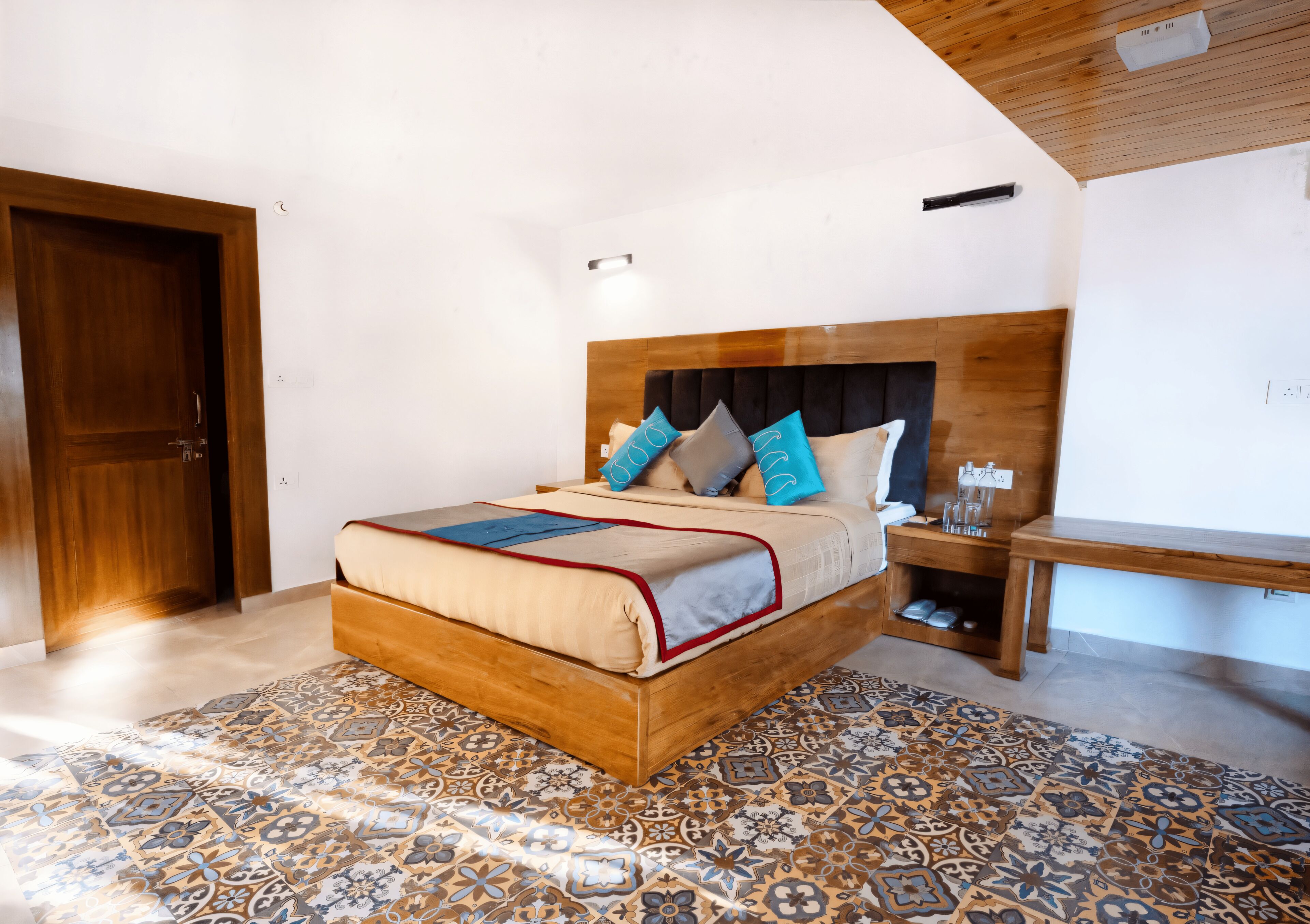 Une chambre à coucher avec un lit en bois, un tapis à motifs et une table de chevet sur laquelle se trouvent des lunettes.
