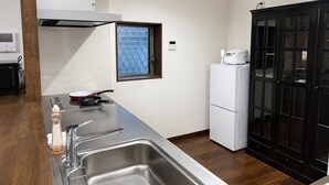 Una cocina compacta con un lavamanos de acero inoxidable, un microondas, una estufa y un refrigerador.