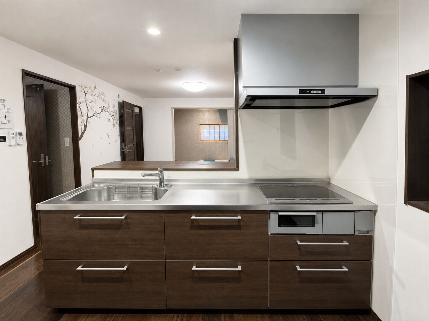 A modern kitchen with a stainless steel sink, wooden cabinets, and a built-in oven.