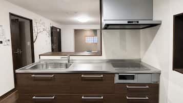 A modern kitchen with a stainless steel sink, wooden cabinets, and a built-in oven.