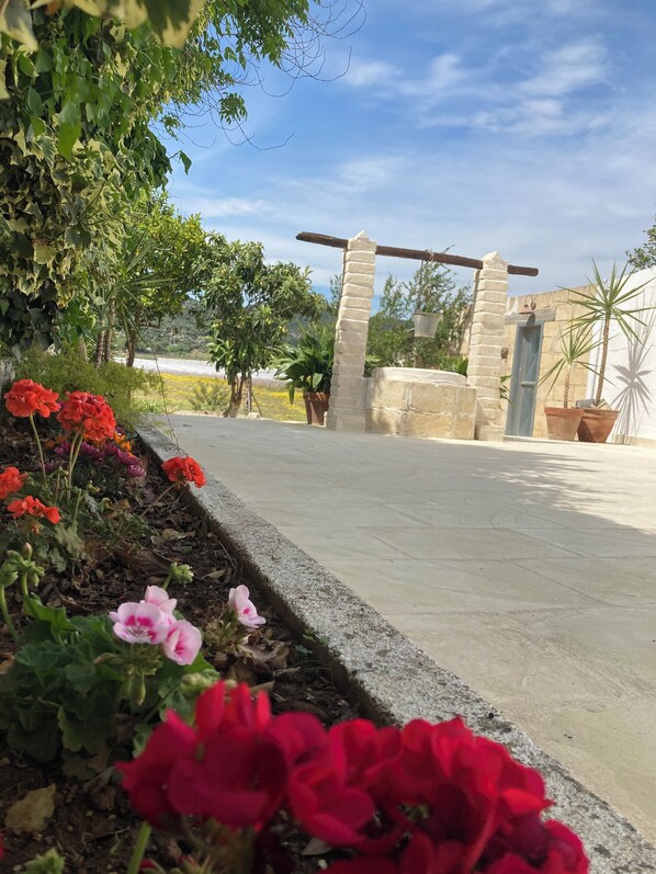 A garden pathway leading to a stone entrance with a wooden archway.