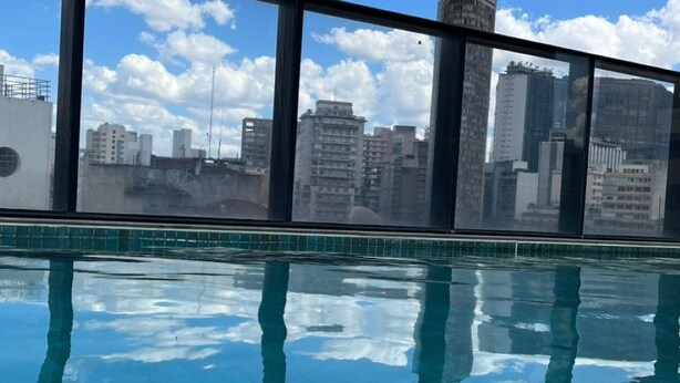 On voit clairement une piscine, avec une vue sur la ville en arrière-plan.