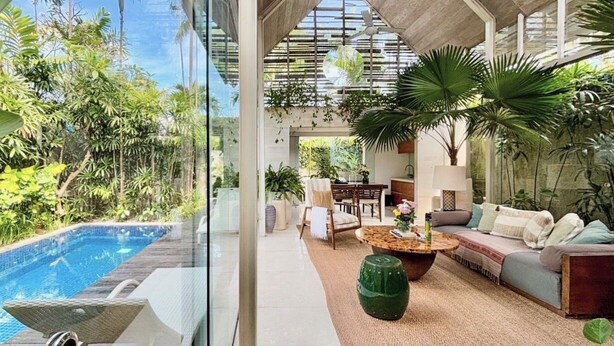 A modern indoor space with a pool, comfortable seating, and abundant greenery. - Kawung Villa Canggu (Canggu)
