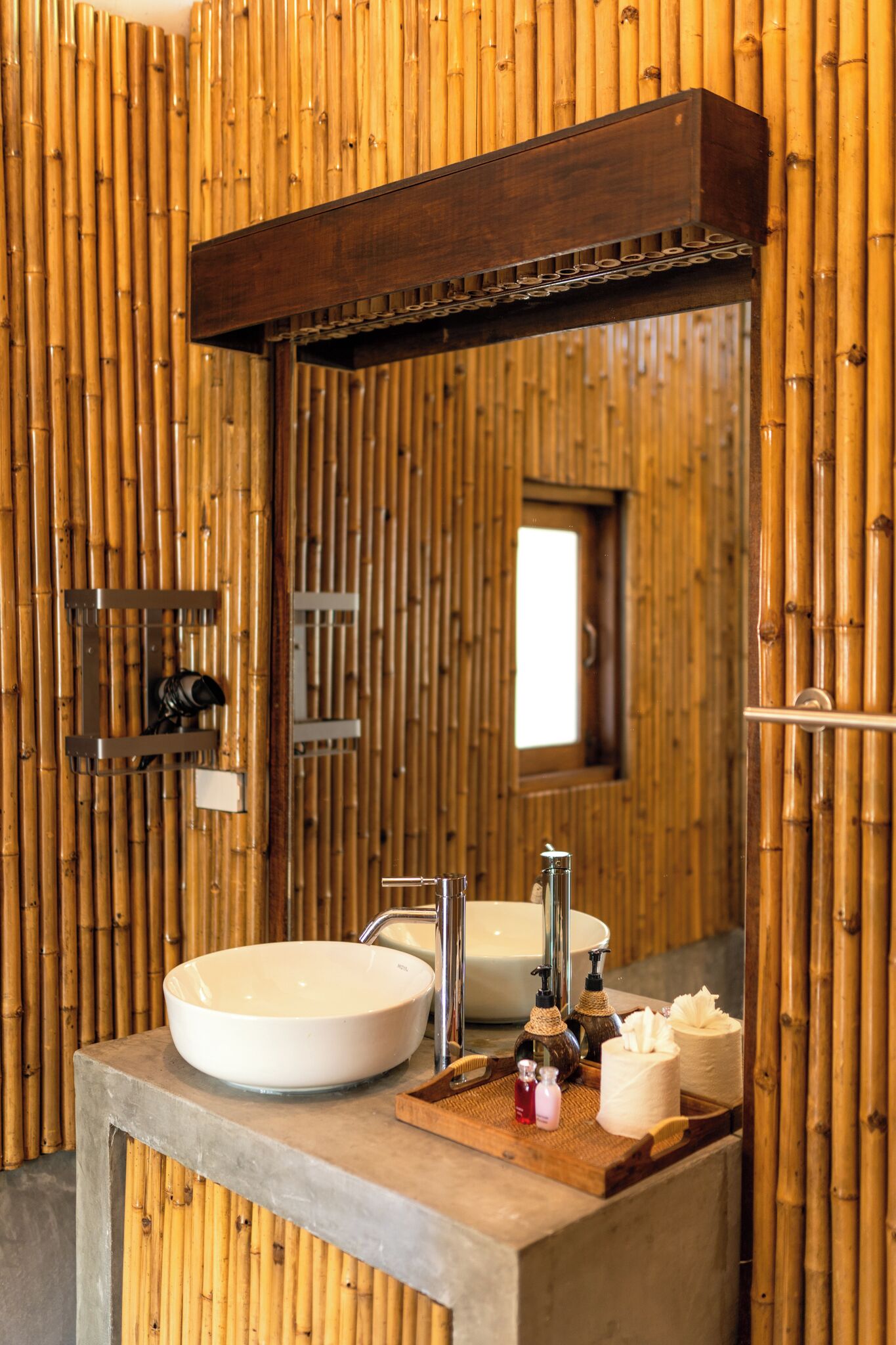 A bathroom with a large mirror, two sinks, and a wooden wall.