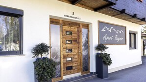 A building with a wooden door labeled "3 HERRNHAUSPLATZ" and a sign that reads "Apart Bogner." - Holiday Home for 3 People in Brixlegg (Brixlegg)