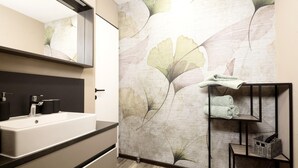 A modern bathroom with a large mirror, a white sink, and a towel rack. - Holiday Home for 3 People in Brixlegg (Brixlegg)