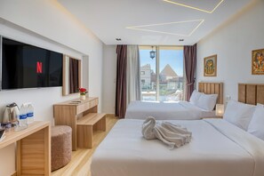 Une chambre d’hôtel moderne avec deux lits, une télévision, un bureau avec une machine à café et une vue sur la ville.