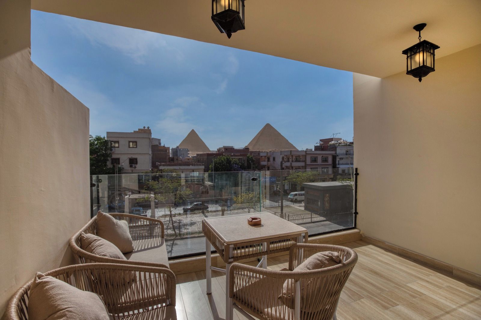 A balcony with wicker furniture and a view of pyramids.