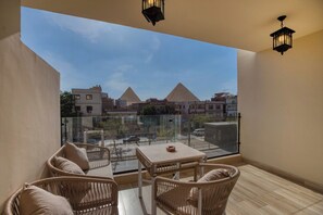 A balcony with wicker furniture and a view of pyramids. - Diamond pyramids hotel (Giza)