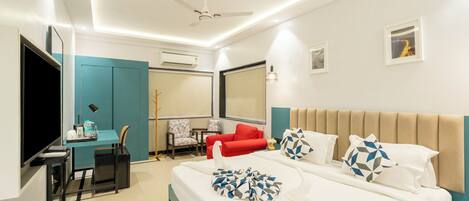 A modern hotel room with a bed, a desk, a TV, and a ceiling fan.