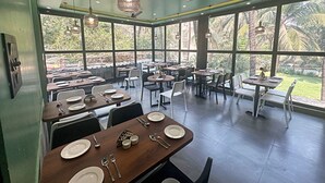 Un restaurante con ventanas amplias, mesas y sillas de madera.