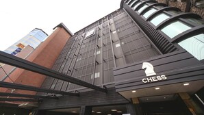 Un edificio moderno con un llamativo logotipo de ajedrez, que indica un establecimiento relacionado con el juego.