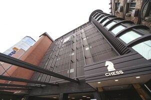 Um edifício moderno com um logotipo de xadrez em destaque, indicando um estabelecimento relacionado a xadrez.