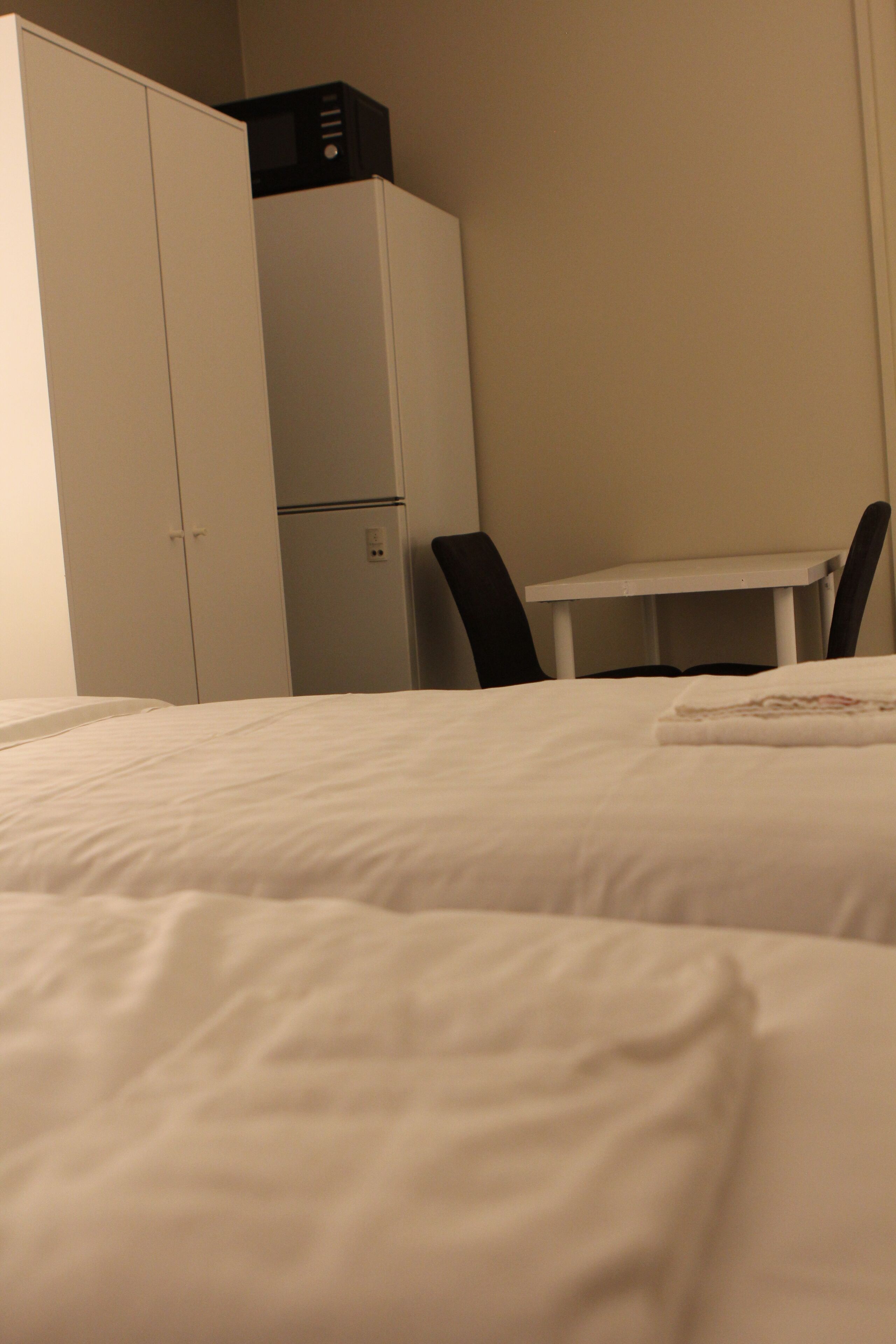 Ein Hotelzimmer mit einem Bett, einem kleinen Tisch und einem Schrank.