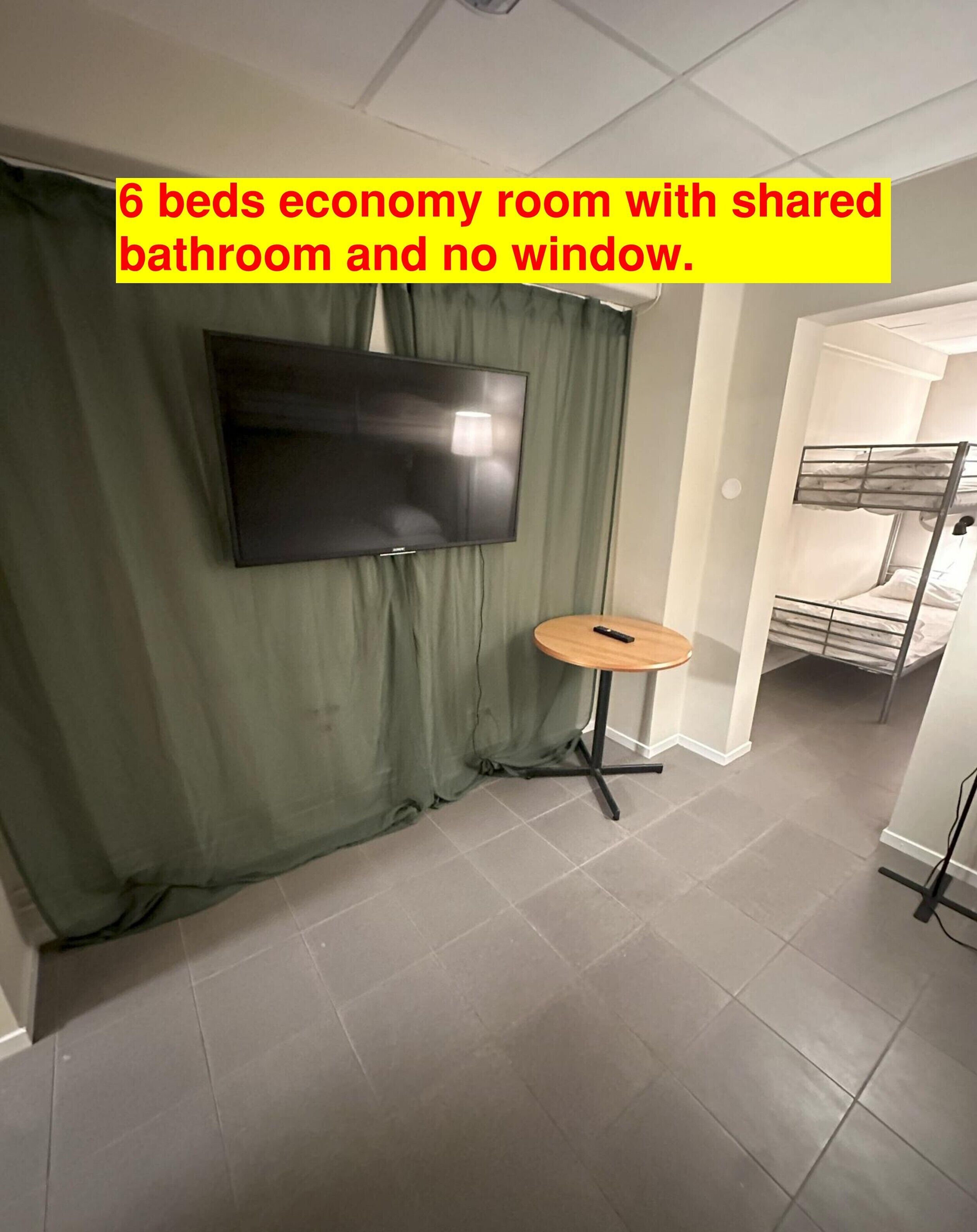 A 6-bed economy room with a shared bathroom and no window.