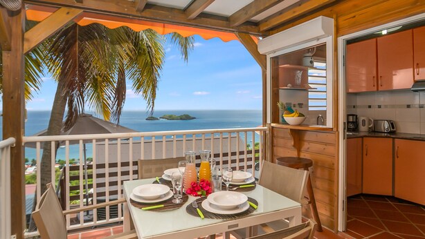 Un comedor con una mesa dispuesta para cuatro, con vistas al mar.