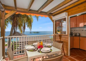 Un comedor con una mesa dispuesta para cuatro, con vistas al mar.