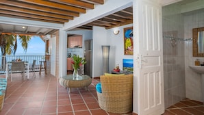 Amplia sala de estar con vista al mar, cocina y baño.