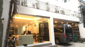Un edificio moderno con entrada de vidrio, una recepción y una furgoneta estacionada.