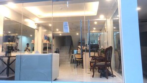 Un interior moderno con un mostrador de recepción, una escalera y una zona de estar.