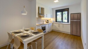 A modern kitchen with white cabinets, a built-in oven, and a window with a view. - Urbanfive 5A Ourense center Duplex Penthouse with terrace (Ourense)